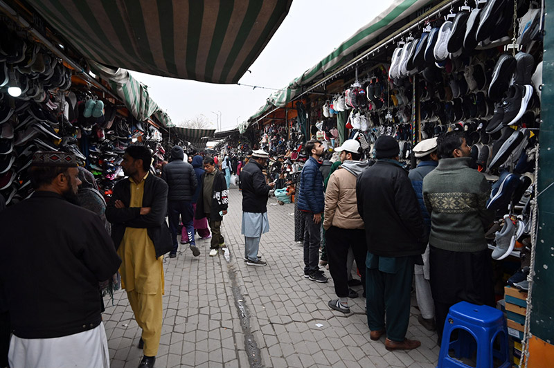 People select and purchase second-hand shoes from vendors at the weekly Sunday Bazaar at H-9 in the Federal Capital