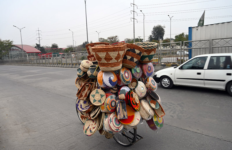 A vendor sells handmade items on his bicycle in the Federal Capital