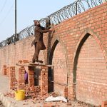 A laborer is working on the construction of the arch of the railway station wall, a symbol of the city’s beauty