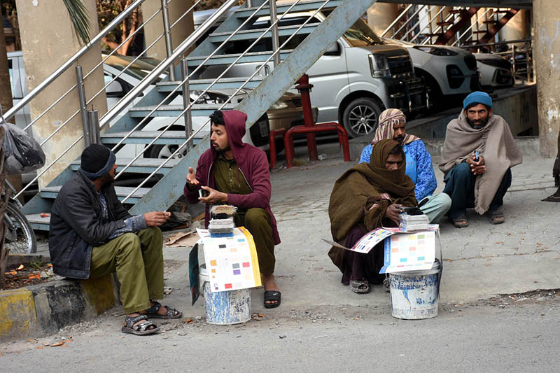 Daily wage laborers wait for customers near Mozang Chungi