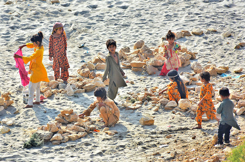 Children are enjoying playing with stone at dry area of Indus River