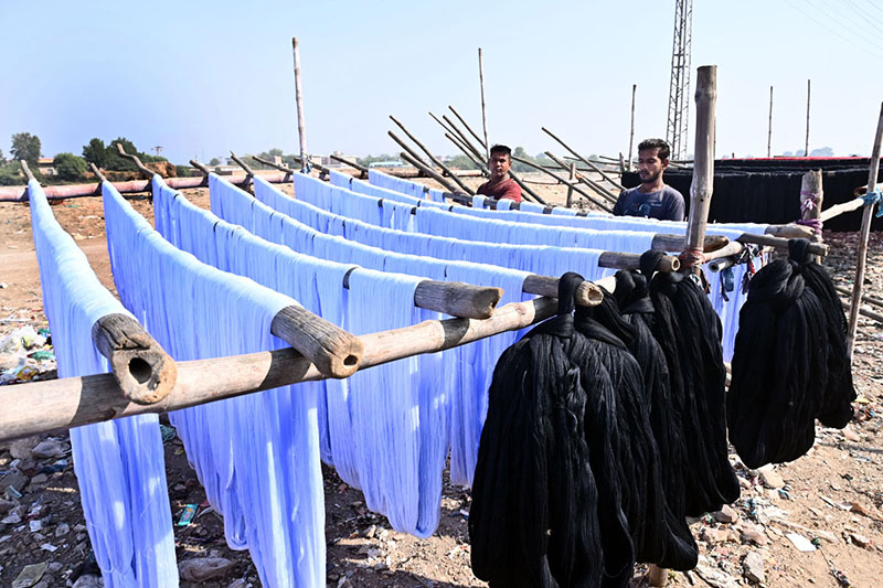 Workers busy dyeing yarn and laying it out to dry in the sun after processing at a factory in the Phulei area