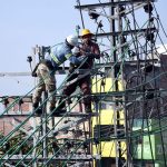 WAPDA workers install new electric transmission wires on a pylon to upgrade the power network