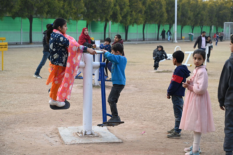 Children enjoying swings at Sukh Chayn Park in Federal Capital