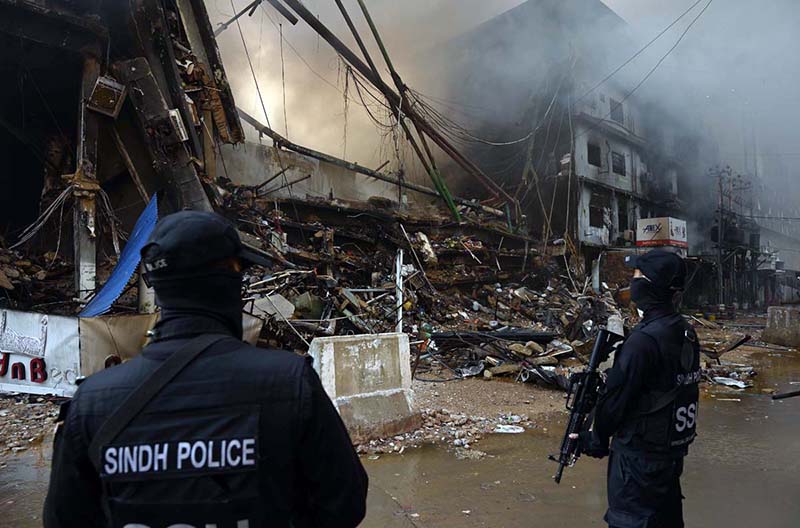 Special Security Unit (SSU) commandos are seen alert at the site of Gul Plaza, where a fire erupted last night
