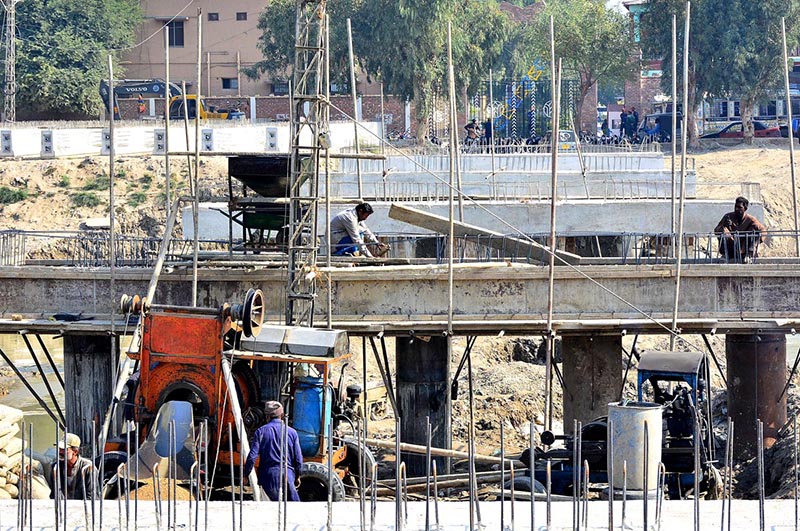 Workers busy in construction work of bridge over the Phulile Canal during development work in the city