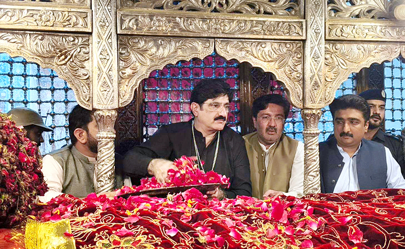 Sindh Chief Minister Syed Murad Ali Shah putting flower petals after laying wreath on the grave of Hazrat Lal Shahbaz Qalandar on the last day occasion of 774th Urs celebration